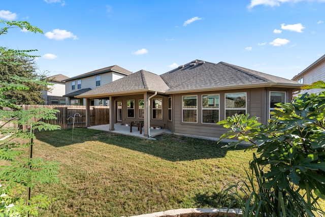 back of house with a patio area and a yard