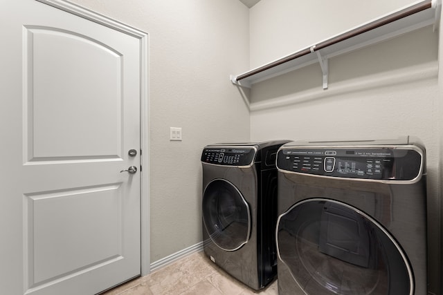 clothes washing area with light tile patterned flooring and washing machine and clothes dryer