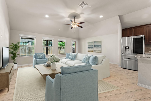 living room with light tile patterned floors, lofted ceiling, ceiling fan, and a healthy amount of sunlight