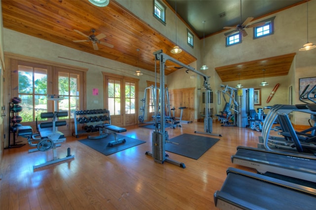 gym with french doors, ceiling fan, a high ceiling, and light wood-type flooring