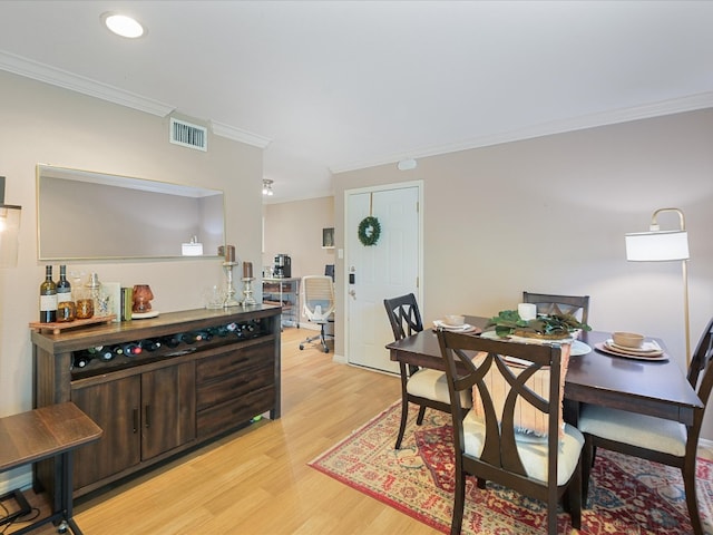 dining area featuring light hardwood / wood-style floors and ornamental molding