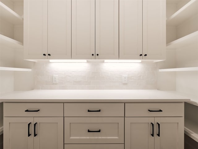 kitchen featuring tasteful backsplash and white cabinetry