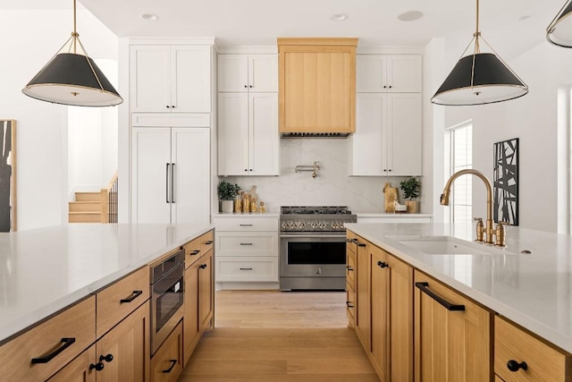 kitchen with backsplash, white cabinets, hanging light fixtures, and premium appliances