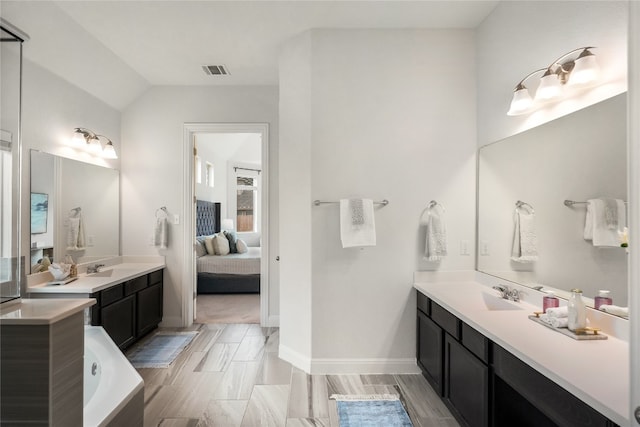 bathroom with lofted ceiling and vanity