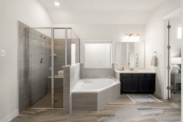 bathroom with lofted ceiling, vanity, and independent shower and bath