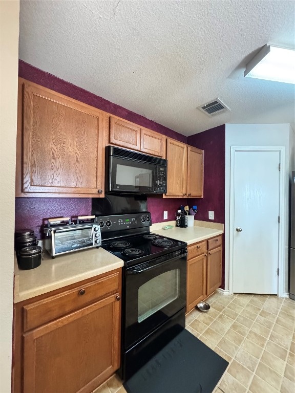 kitchen featuring black appliances and a textured ceiling