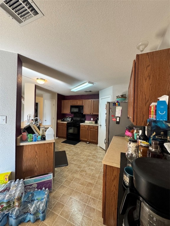 kitchen featuring black appliances and a textured ceiling