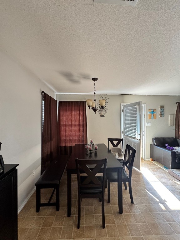 dining area featuring a textured ceiling and an inviting chandelier