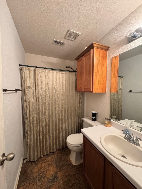 bathroom with toilet, vanity, and a textured ceiling