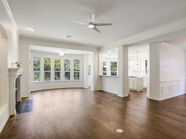 unfurnished living room featuring ceiling fan, dark wood-type flooring, and crown molding