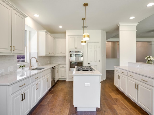 kitchen with pendant lighting, a center island, sink, white cabinetry, and appliances with stainless steel finishes