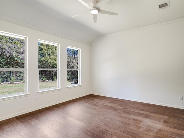 empty room with ceiling fan, vaulted ceiling, dark hardwood / wood-style floors, and ornamental molding