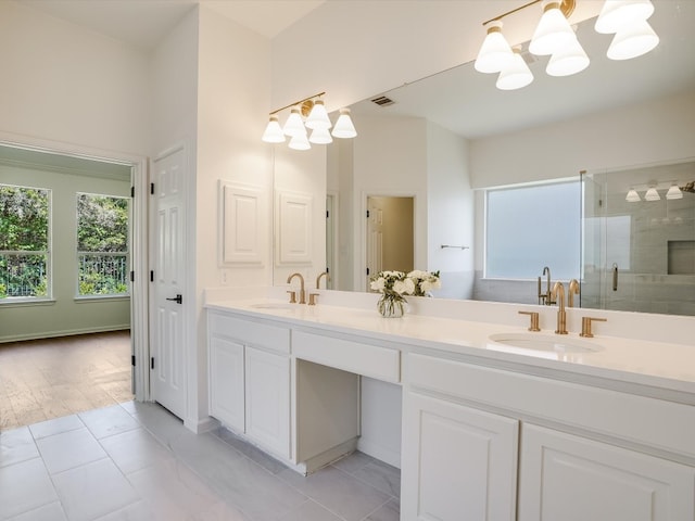 bathroom with tile patterned flooring, walk in shower, a chandelier, and vanity