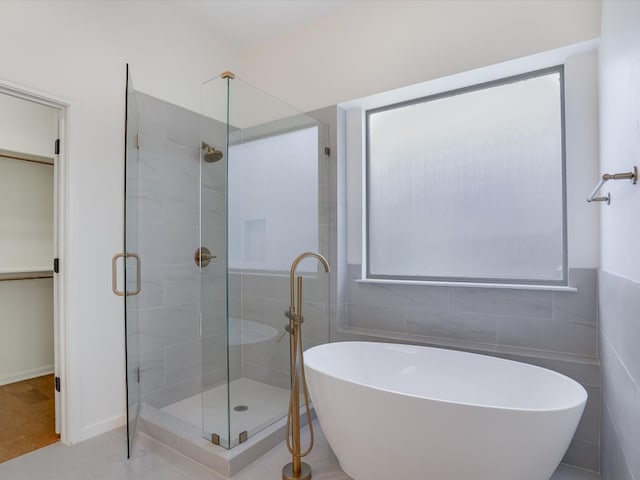 bathroom featuring independent shower and bath, tile walls, and tile patterned floors