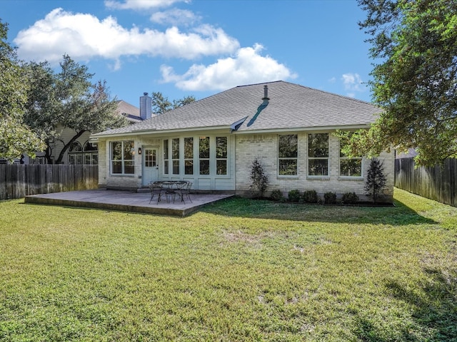 rear view of property with a yard and a patio