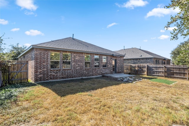 rear view of property featuring a patio and a lawn