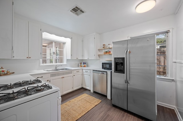 kitchen with white cabinets, dark hardwood / wood-style flooring, plenty of natural light, and appliances with stainless steel finishes