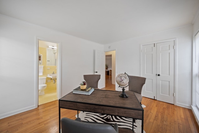 office space featuring light wood-type flooring and ornamental molding