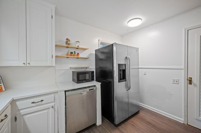 kitchen with dark wood-type flooring, white cabinets, crown molding, and stainless steel appliances