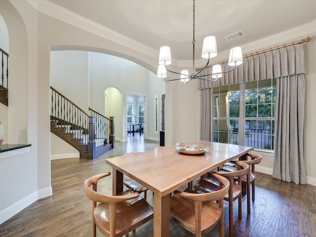 dining space with dark hardwood / wood-style floors, crown molding, and an inviting chandelier