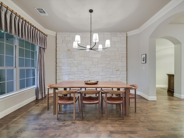 dining area featuring ornamental molding, dark wood-type flooring, and a notable chandelier