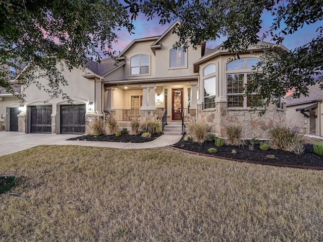 view of front of property featuring a garage, a lawn, and a porch