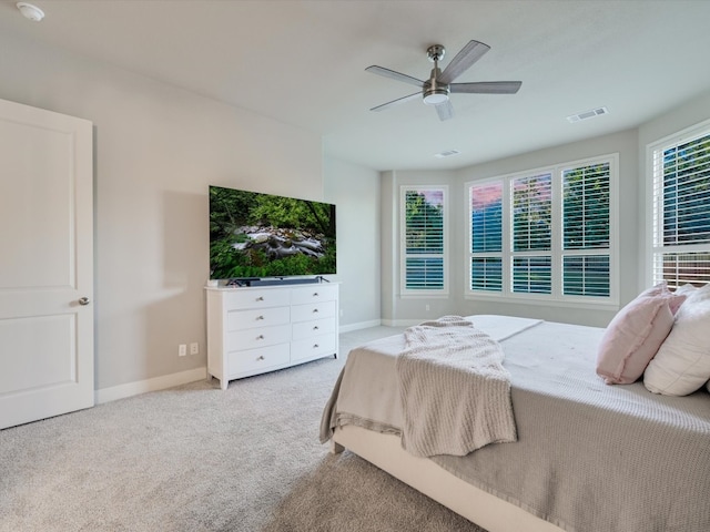 carpeted bedroom with ceiling fan and multiple windows