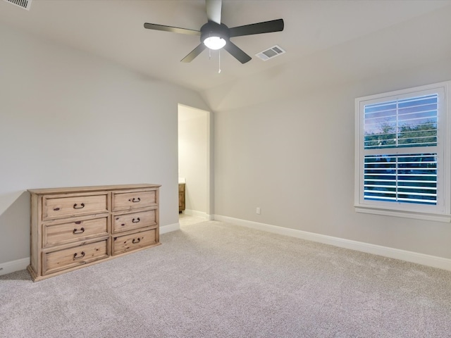 unfurnished bedroom with ceiling fan, vaulted ceiling, and light colored carpet