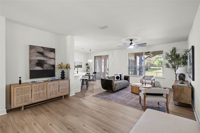 living room featuring ceiling fan and light wood-type flooring