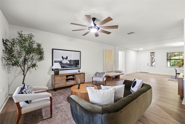 living room with wood-type flooring and ceiling fan