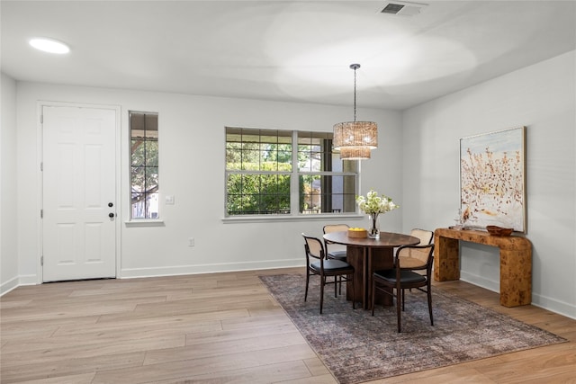 dining space featuring an inviting chandelier and light wood-type flooring