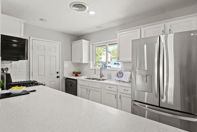 kitchen with black dishwasher, white cabinetry, stainless steel refrigerator with ice dispenser, sink, and backsplash