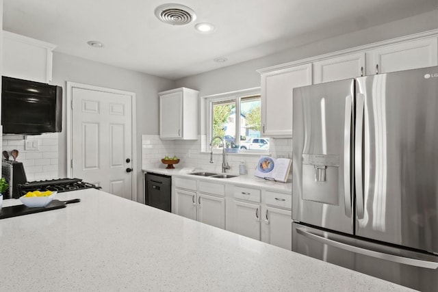 kitchen with black dishwasher, visible vents, white cabinetry, stainless steel refrigerator with ice dispenser, and a sink