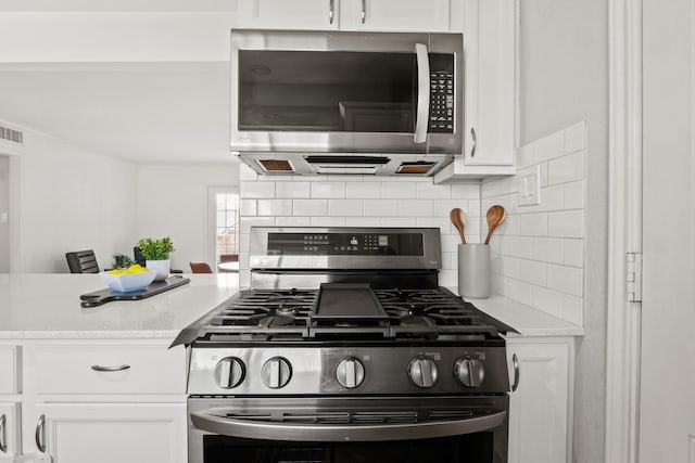 kitchen featuring tasteful backsplash, white cabinetry, and stainless steel appliances