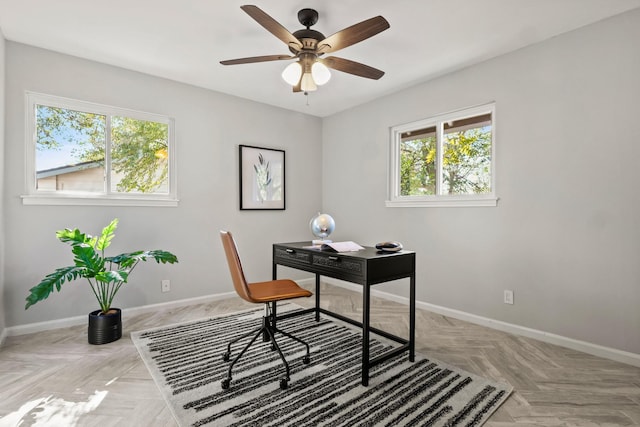 office space with light parquet floors and ceiling fan