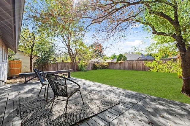 deck with a fenced backyard and a lawn