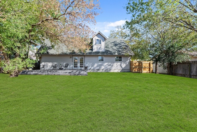 rear view of house featuring a lawn and french doors