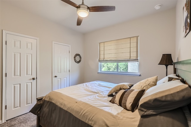 bedroom with carpet flooring, ceiling fan, and two closets