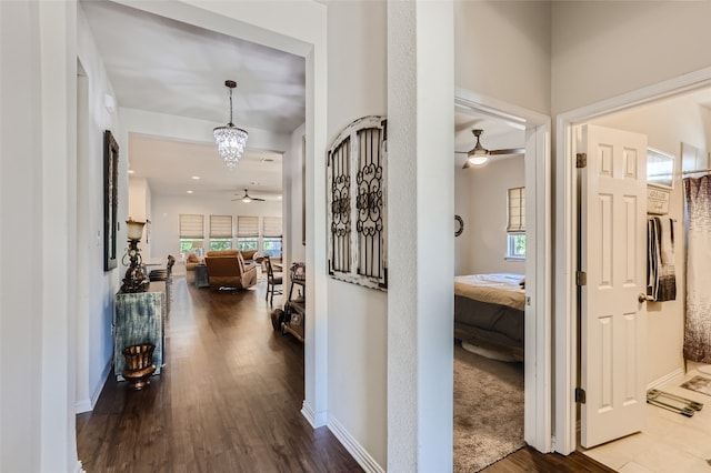 hall featuring an inviting chandelier and hardwood / wood-style flooring