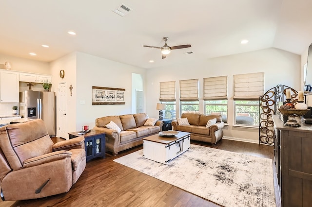 living room featuring dark hardwood / wood-style floors, ceiling fan, and vaulted ceiling