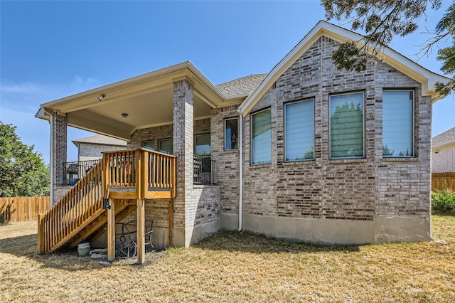 exterior space featuring a front lawn and a wooden deck