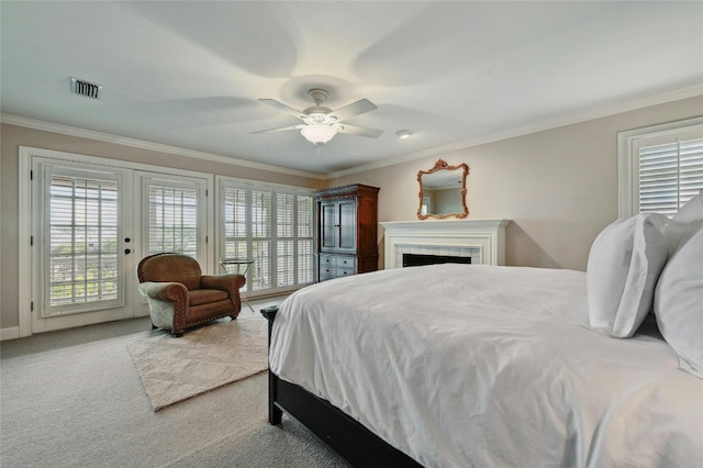 carpeted bedroom with access to outside, a tile fireplace, ceiling fan, and crown molding