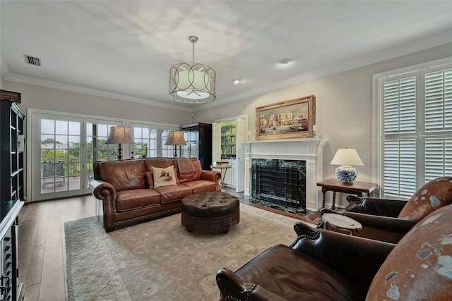 living room featuring crown molding, a high end fireplace, and wood-type flooring