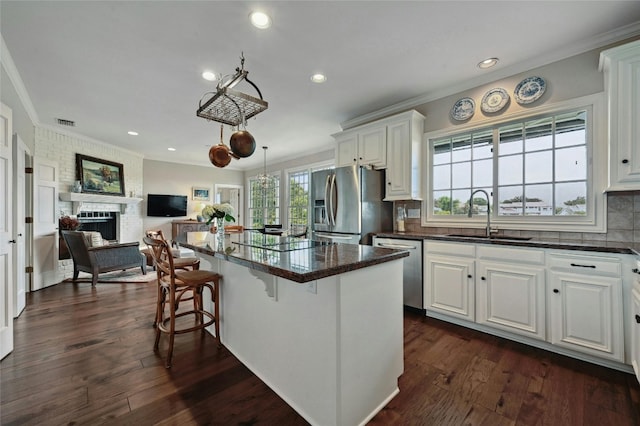 kitchen with white cabinets, sink, appliances with stainless steel finishes, and dark wood-type flooring