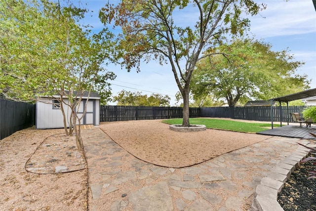 view of yard featuring a fenced backyard, an outdoor structure, a shed, and a wooden deck
