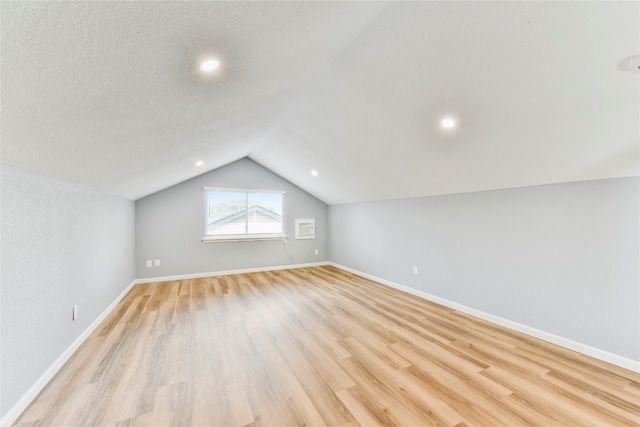 bonus room featuring light wood-type flooring and vaulted ceiling