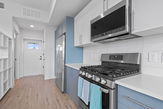 kitchen featuring light countertops, appliances with stainless steel finishes, visible vents, and white cabinetry