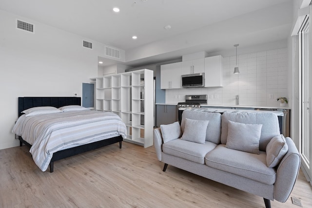 bedroom with light wood-style flooring, visible vents, and recessed lighting