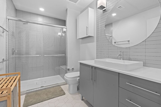 bathroom with toilet, vanity, visible vents, a shower stall, and tile patterned floors