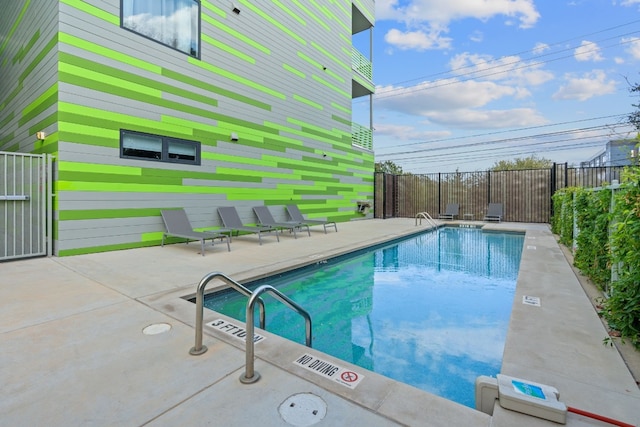 community pool featuring fence and a patio